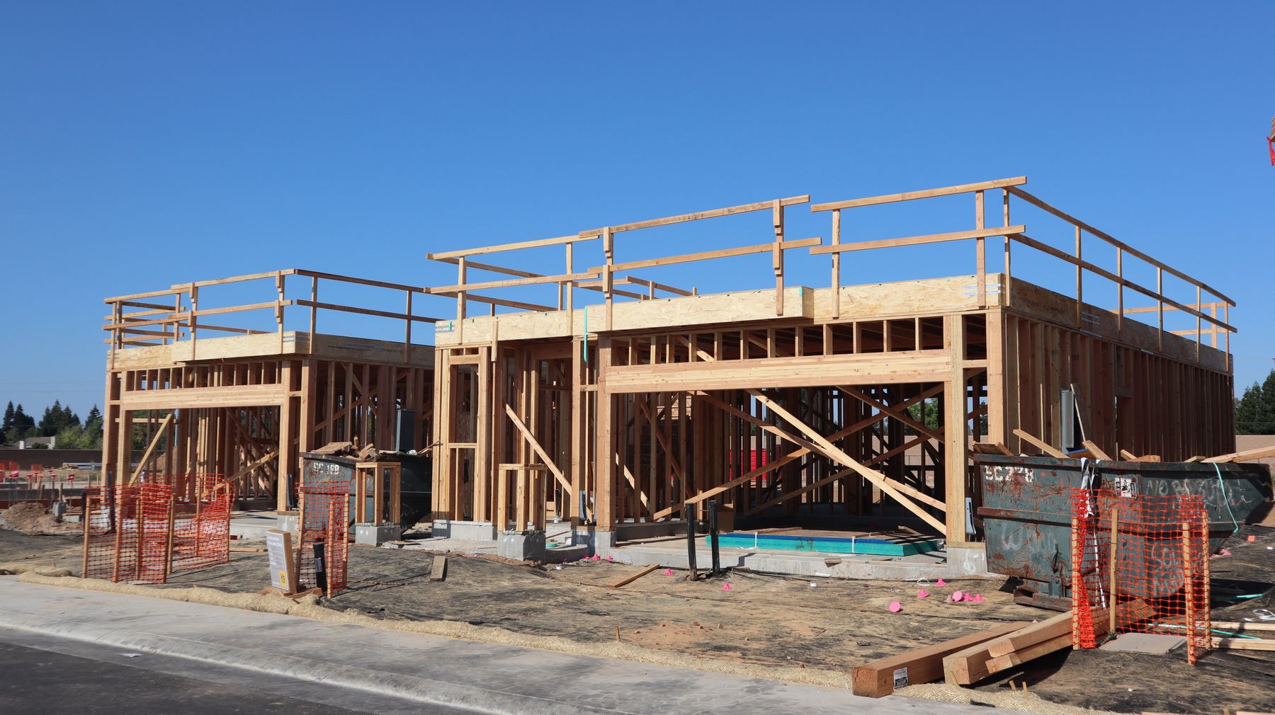 Two-story home framing under a clear sky