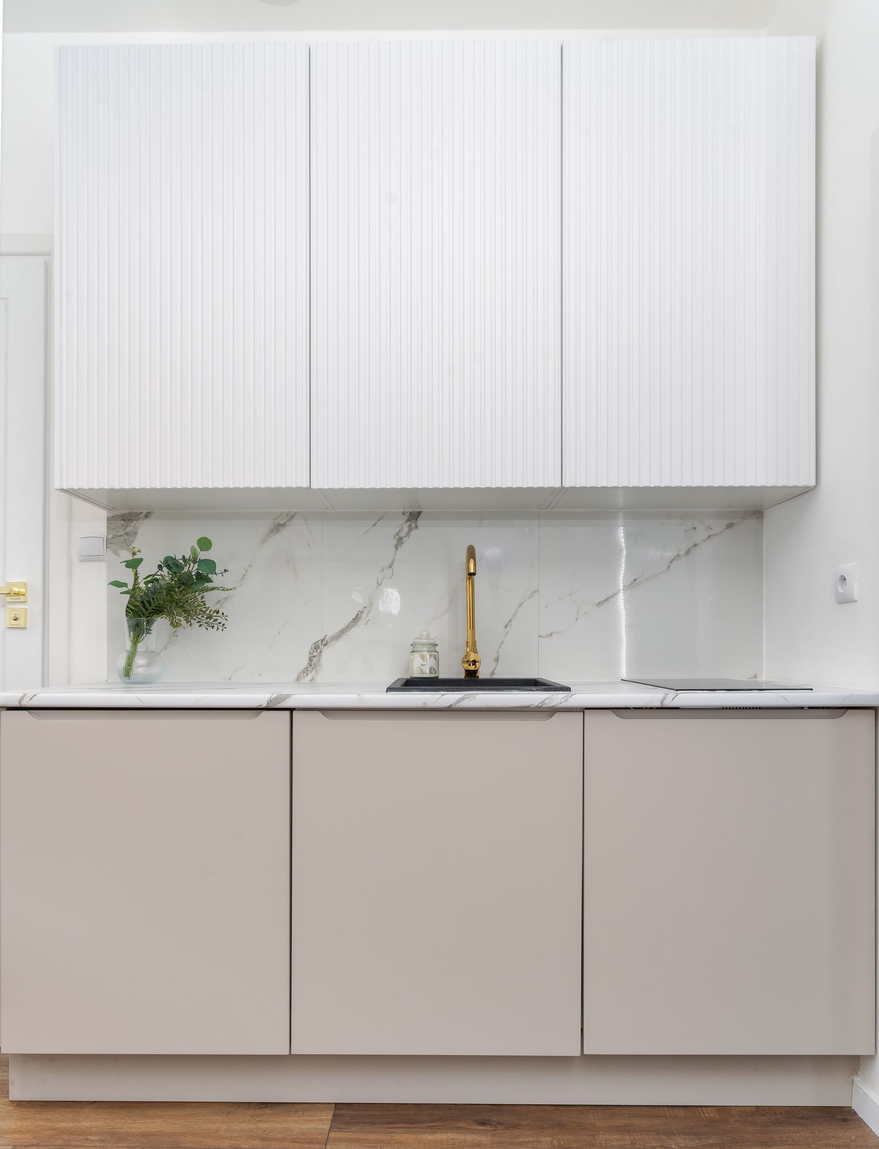 Close-up of a marble backsplash and brass faucet